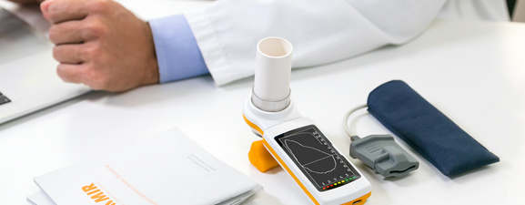 An MIR brochure, professional spirometer, and other medical equipment on a table.