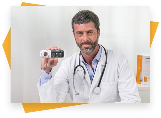 A white, bearded male medical provider wearing a white lab coat and stethoscope holding a Spirodoc professional spirometer.